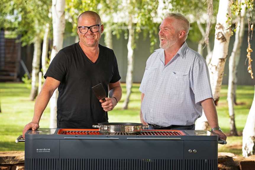 Celebrity chef Heston Blumenthal stands in front of a barbeque with Murray Cod Australia chairman Ross Anderson.