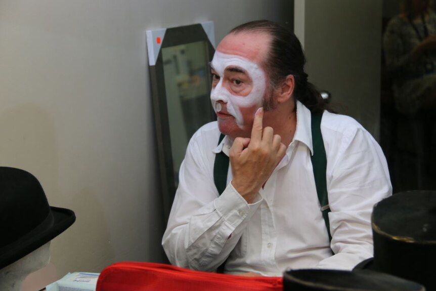 Close-up of Martin Jacques applying white pancake make-up.