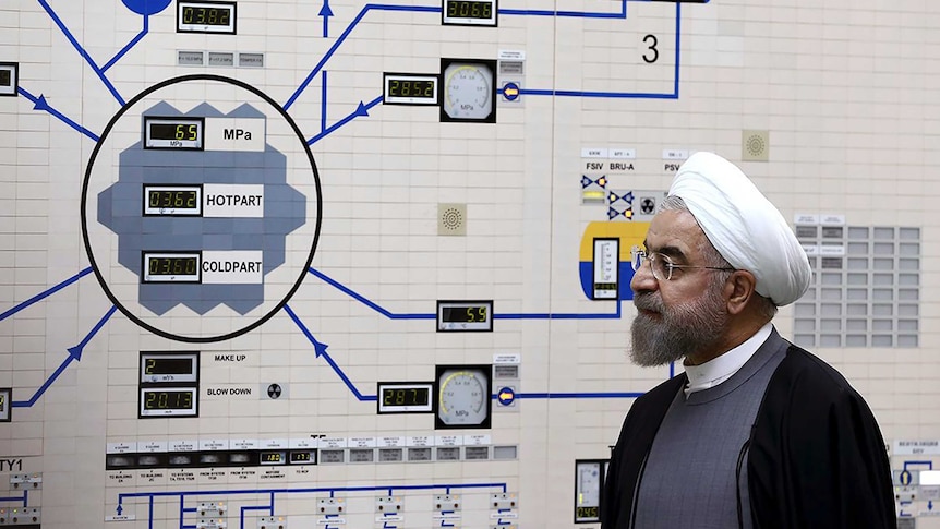 President Hassan Rouhani visits the Bushehr nuclear power plant, with a complex machine in front of him