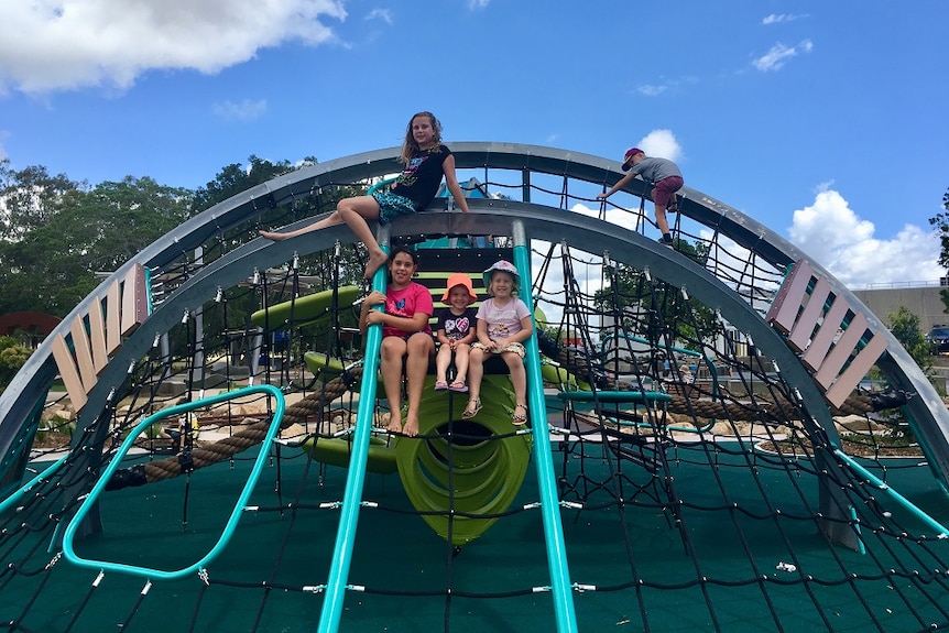 Five children play on playground equipment designed for those with sensory issues.