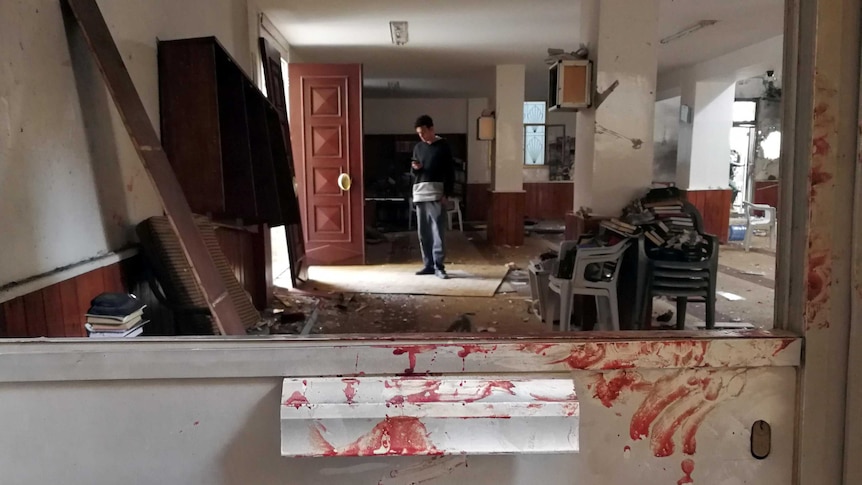 Bloody hand prints stains a dooras soldiers inspect a twin bombing inside a mosque in Benghazi