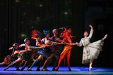 A line of ballet dancers on stage leading to a prima ballerina playing Cinderella