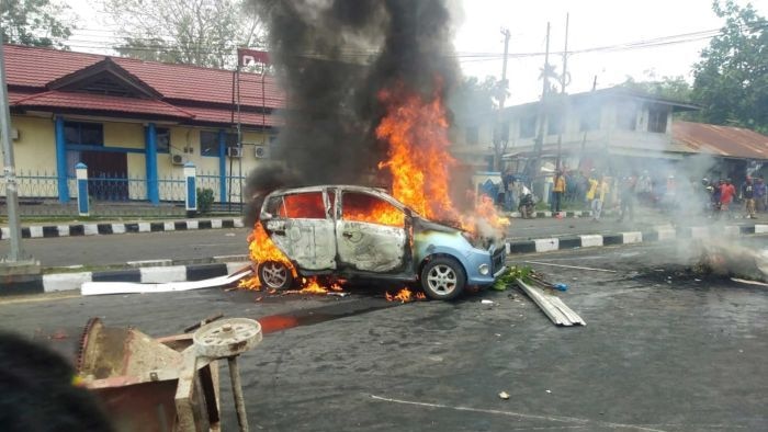 Massa aksi membakar mobil