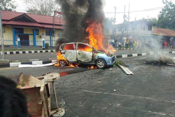 Massa aksi membakar mobil