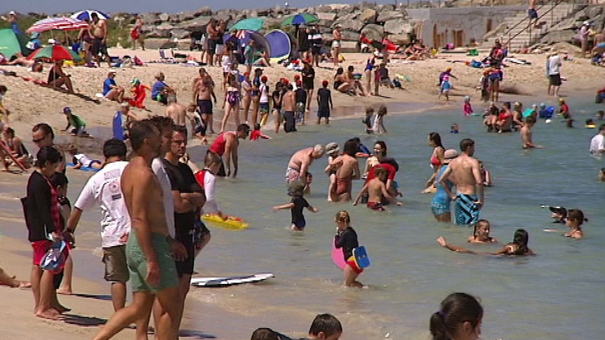 Swimmers crowd a Perth beach