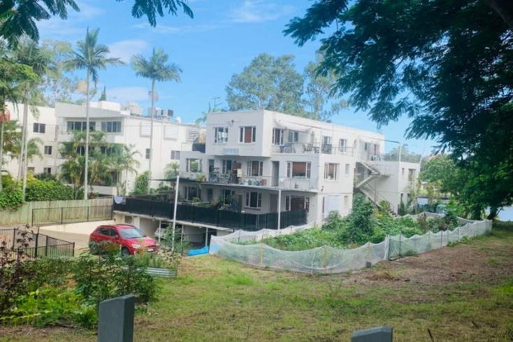 A riverside unit block with an adjoining community garden.