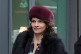 A smiling woman with a purple fur hat.