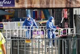 Two people dressed in blue taking pictures at a fairground 