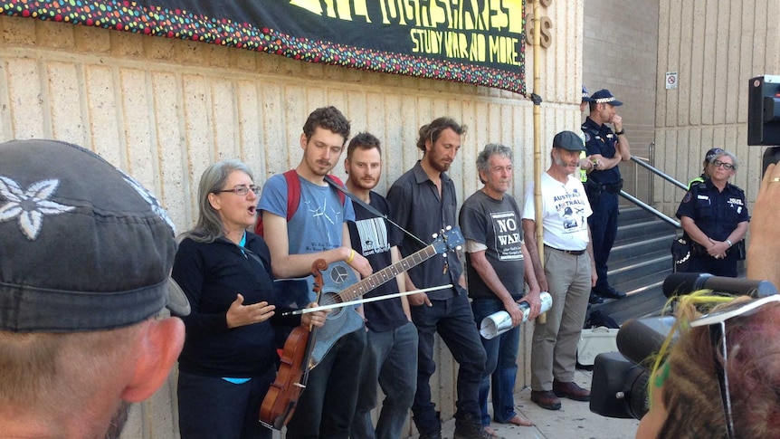 Five activists play a song in front of supporters outside Alice Springs court.