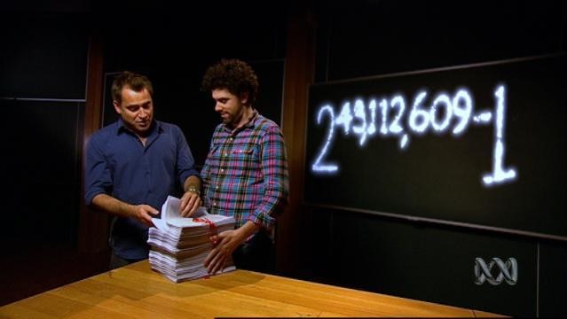 Two men look at stack of papers