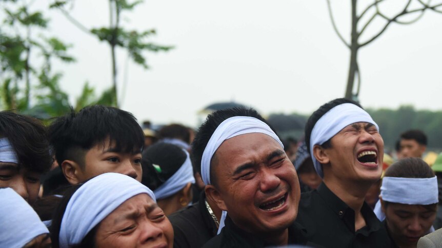 Familiy members weep during a funeral in Vietnam.