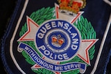 Queensland police badge says "with honour we serve"