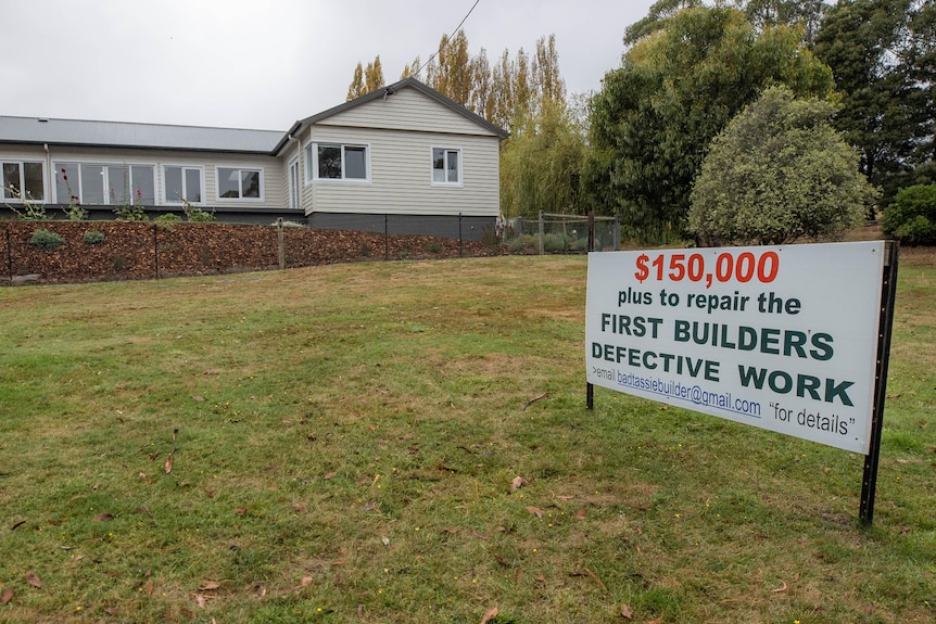 A sign in the front yard of a house