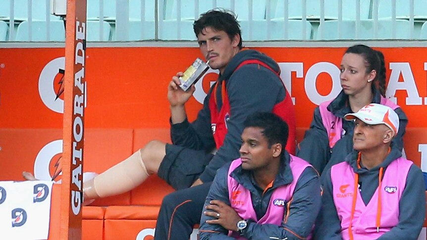 GWS defender Phil Davis sits on the bench after injuring his ankle against Collingwood.