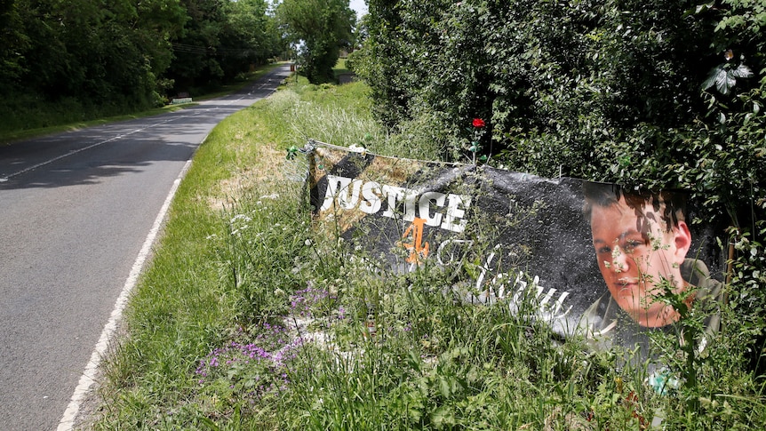 A banner and a memorial area on the roadside for British teenager Harry Dunn.