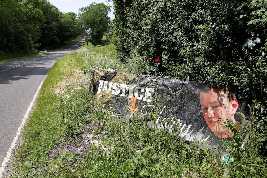 A banner and a memorial area on the roadside for British teenager Harry Dunn.