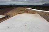 A landfill site with a large white "membrane" over the top.