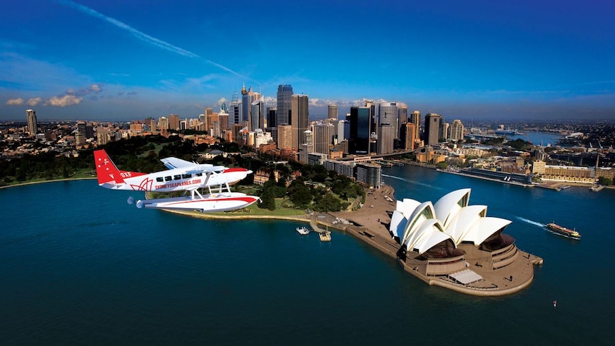 A Sydney Seaplanes aircraft flies over the Sydney Opera House.