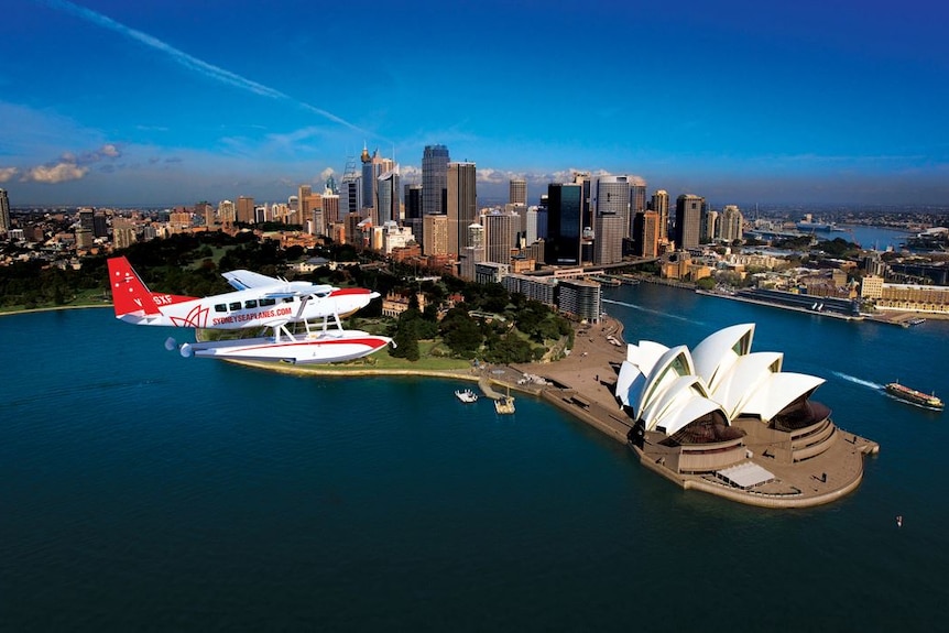 A Sydney Seaplanes aircraft flies over the Sydney Opera House.