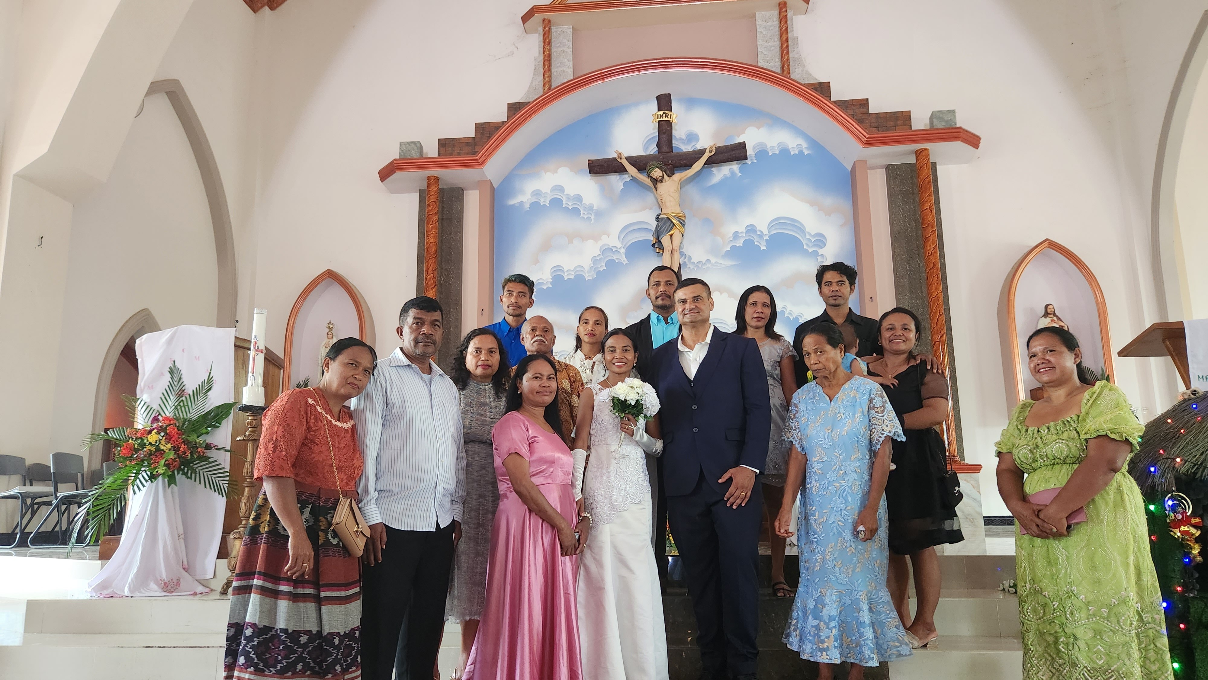 Michael and Bella, surrounded by Bella's family, after their wedding in a local Catholic church.