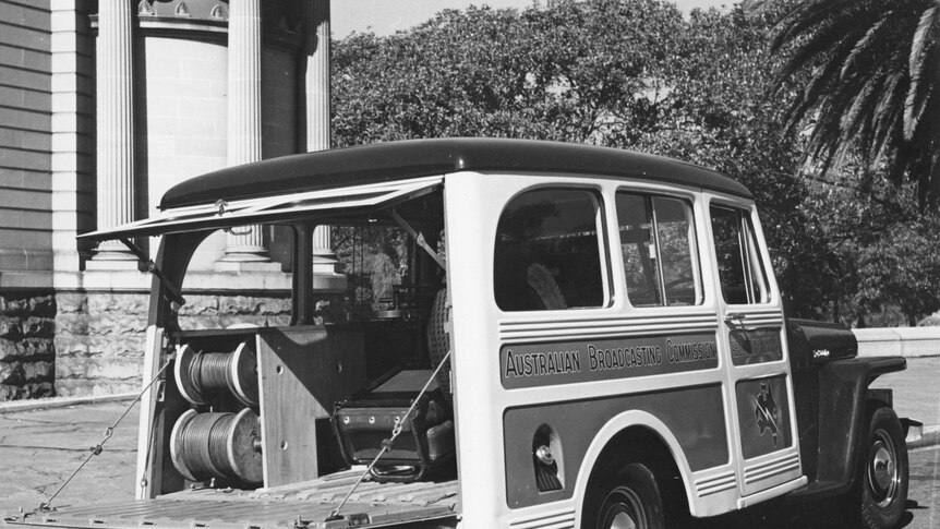 Black and white photo of the ABC van from the 1950's, loaded with recording equipment.