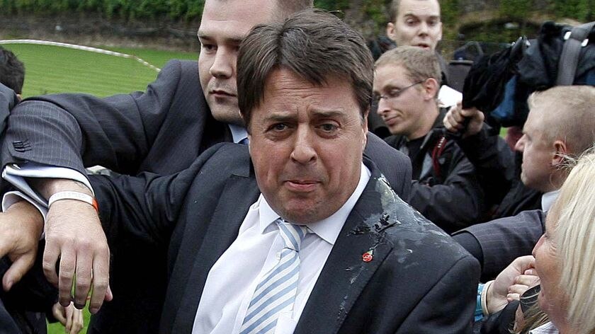 Egg attack.. BNP leader Nick Griffin leaves a press conference after being pelted.