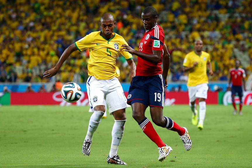 Fernandinho and Adrian Ramos compete for the ball
