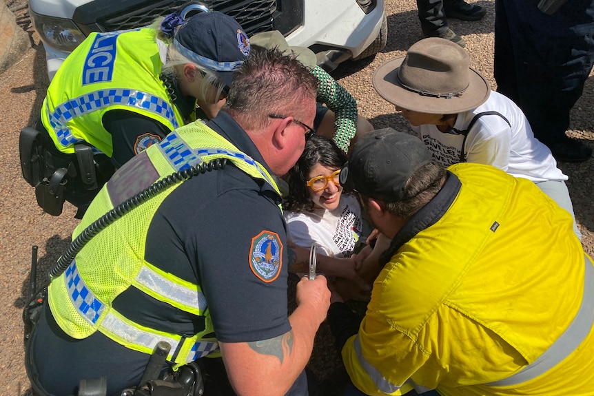 A woman is surrounded by police.