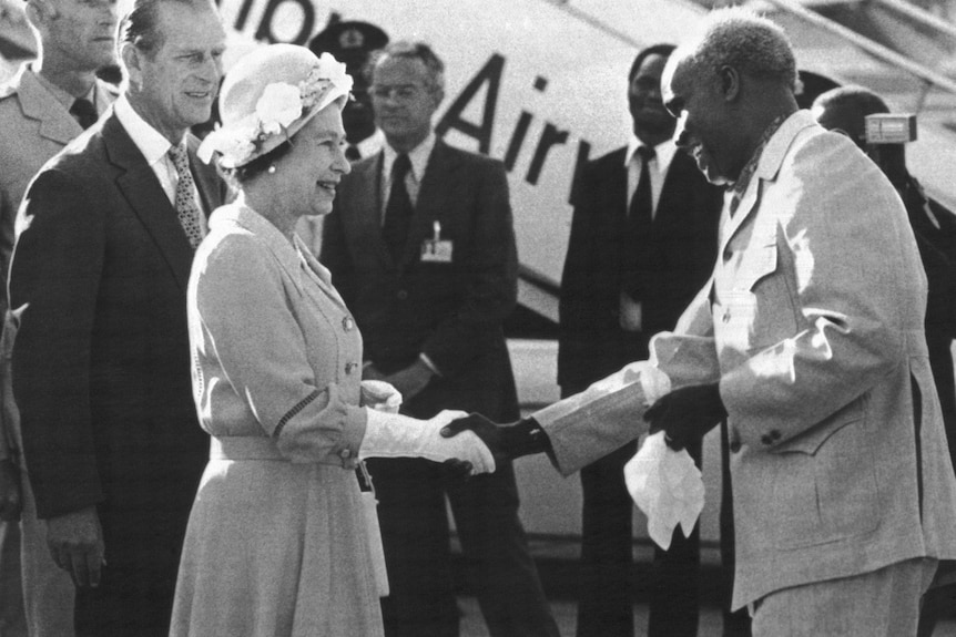 Queen Elizabeth shakes hands with Kenneth Kaunda in a black-and-white image