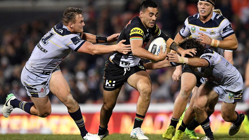 Penrith's Tyrone May is tackled by Nth Queensland Cowboys Coen Hess (L) and Jake Granville.