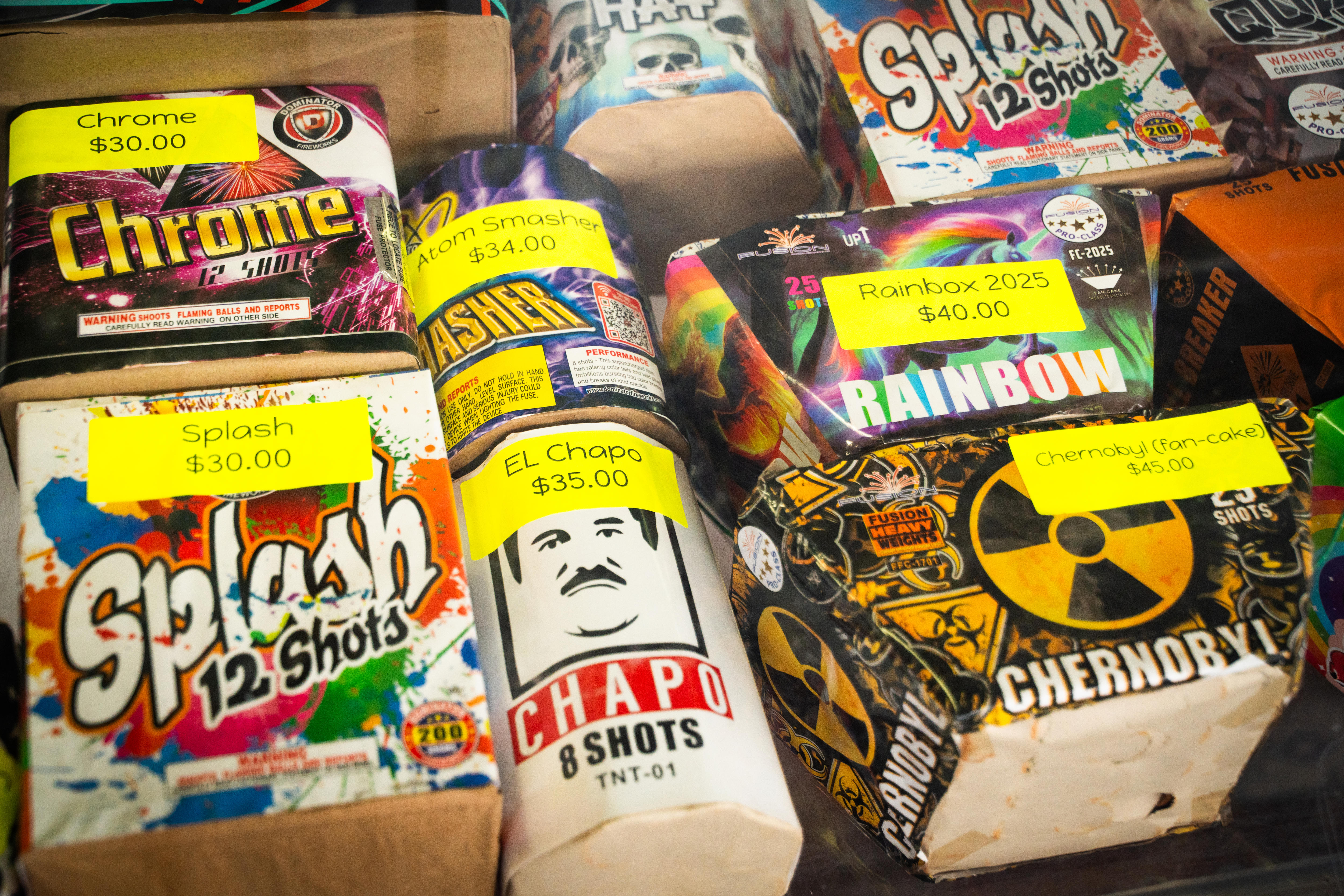 An array of small, brightly coloured boxes, holding fireworks, arranged on a store shelf.
