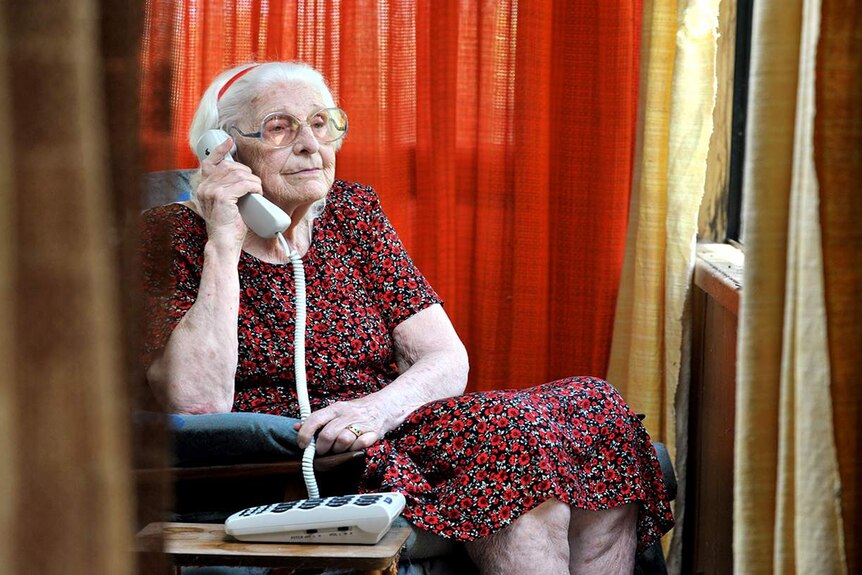 Elderly lady holds telephone