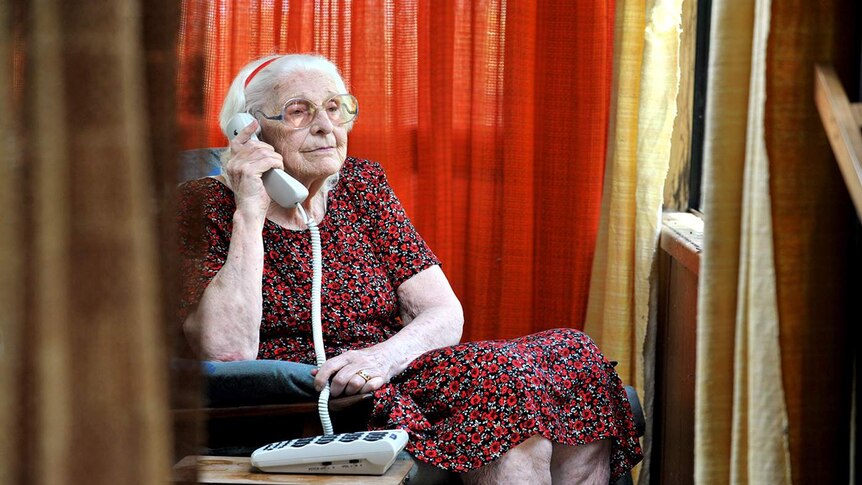 Elderly lady holds telephone