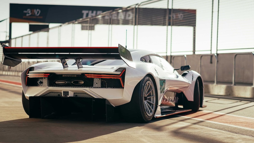 A white and green race car on a race track