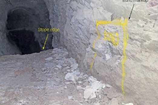 A photograph inside an underground gold mine with markings showing the edge of an open void known as a stope.