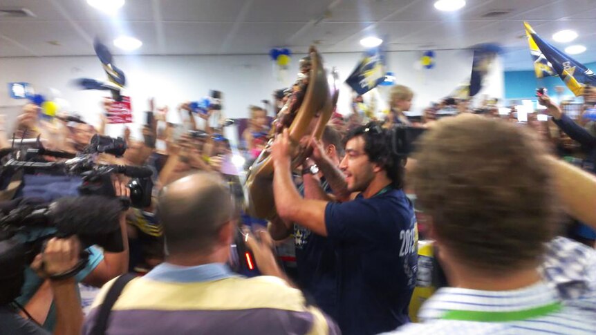 Johnathan Thurston and Cowboys co-captain Matt Scott hold the NRL premiership trophy aloft as they greet fans at Townsville Airport