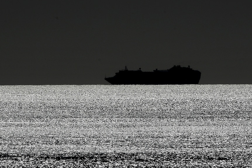 A silhouette of a cruise ship on water.