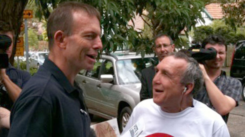 Unfazed: Tony Abbott talks to a voter outside a polling station in Bradfield.