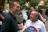 Unfazed: Tony Abbott talks to a voter outside a polling station in Bradfield.