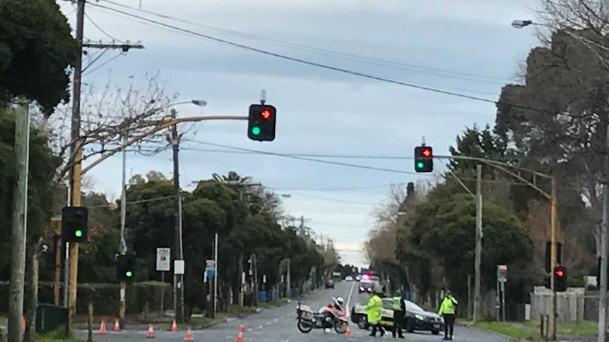 Police block off an intersection in Brighton after a cyclist is killed by a truck.