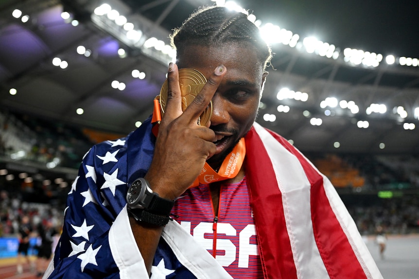 An American male athlete celebrates with his gold medal at the world championships.