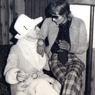 A black and white photo showing Rose Black sitting on the knee of Perth brothel madam Shirley Finn.