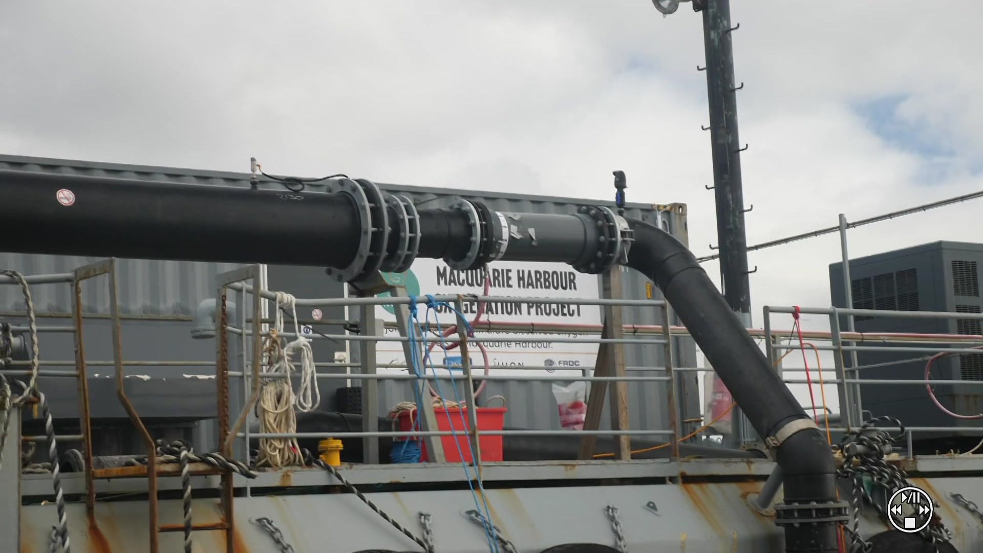 Close up of side of barge carrying a large grey shipping container