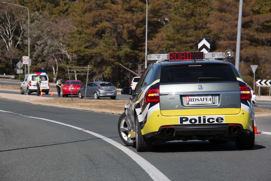 A police car pulled across a closed road.