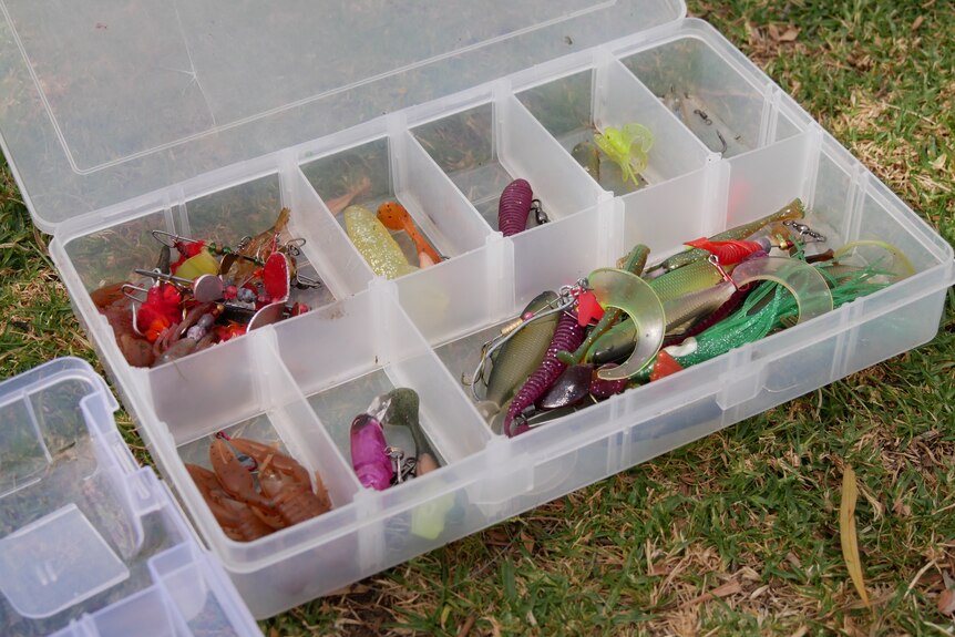 a tackle box of fishing gear is laid out