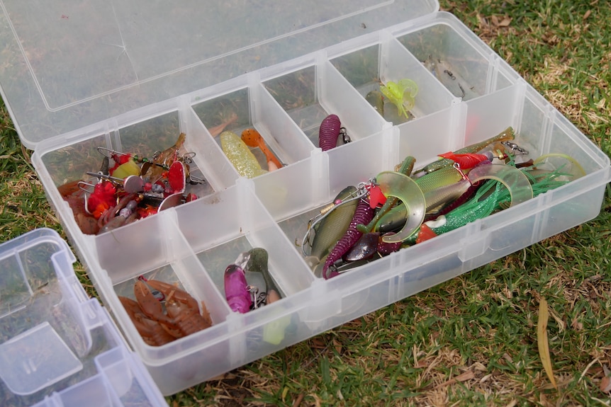 a tackle box of fishing gear is laid out