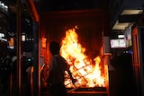 The entrance to a subway station in Hong Kong is set on fire as someone looks on.