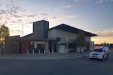 Ellenbrook Police Station with a police car driving by.