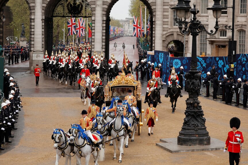 high angle view of horses drawing a carriage surrounded by royal guards