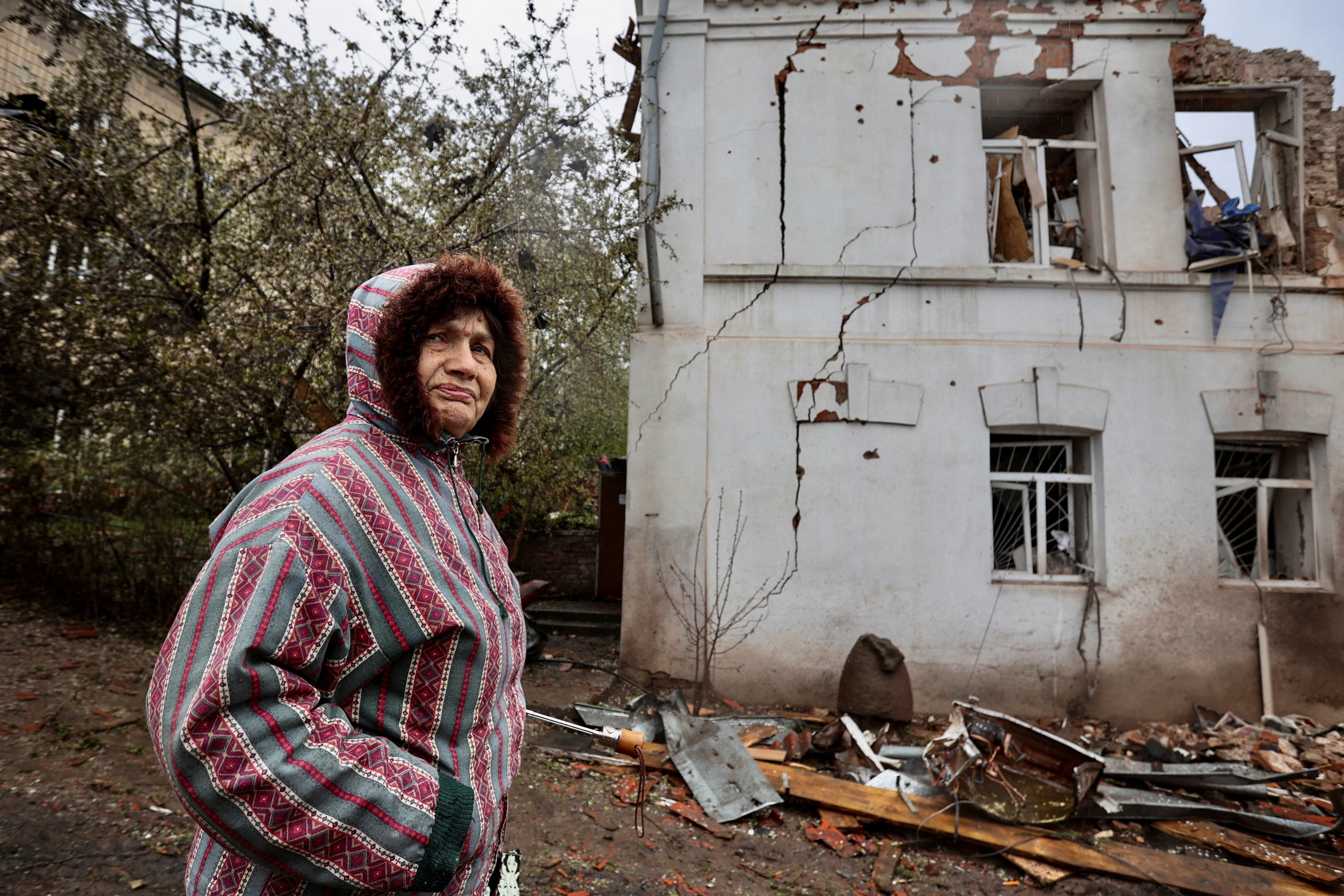 A local resident stands next to a museum building, heavily damaged by a Russian missile strike.